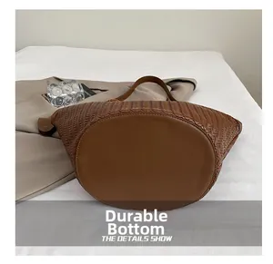 Dettaglio del fondo resistente all'usura della borsa tote marrone intrecciata