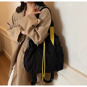 Details einer Nylon-Tasche mit gelben Kontrastriemen an einem modischen Model
