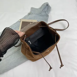 Chic vintage brown suede drawstring backpack showing internal pocket and magnetic closure