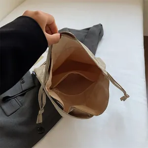 Minimalistische stoffen handtas met trekkoord, ruim interieur en ritsvakje
