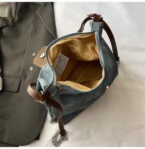 Détail du sac en jean bleu avec anses en cuir marron et doublure jaune spacieuse