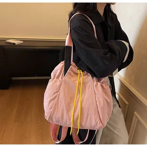 Detailansicht der pinkfarbenen Nylontasche mit gelben Kordeln und schwarzen Trägern