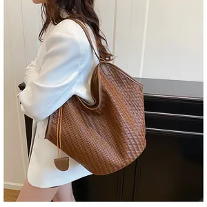 Dettaglio macro della trama in pelle intrecciata marrone di una borsa tote ampia