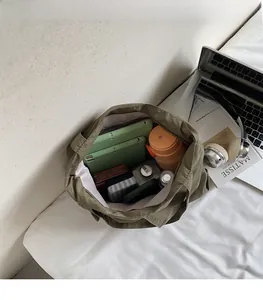 Top view of olive green tote bag interior showing capacity for tablets and daily essentials