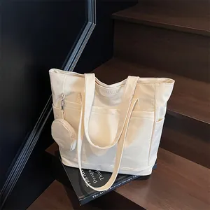 Minimalist off-white canvas tote bag with large capacity and matching coin purse on wood