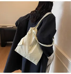 Close-up of minimalist beige canvas tote bag with front pocket shown in a lifestyle setting
