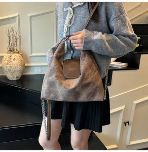 Détail du sac cabas vintage taupe avec rabat en cuir marron et détails de chaîne argentée