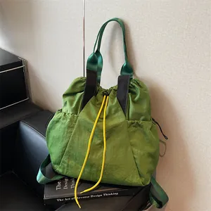 Grüner Nylon-Kordelzug-Rucksack mit gelber Kordel und breiten Gurten für die Reise