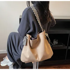 Detail view of camel tote bag with striped scarf knot and matching shoulder strap