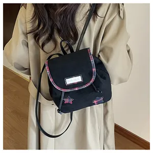 Close-up of black canvas backpack with red plaid star appliqué and Serendipity tag