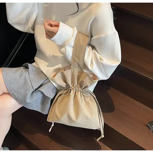 Detail van de kaki handtas met trekkoord, minimalistisch design en zachte stof
