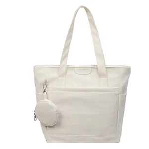 Minimalist beige canvas tote bag with leather label and round coin purse charm