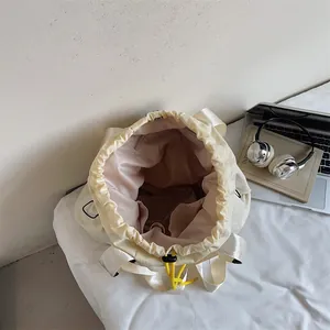 Cremefarbener Kordelzug-Rucksack mit rosa Innenfutter und Innentaschen mit Laptop