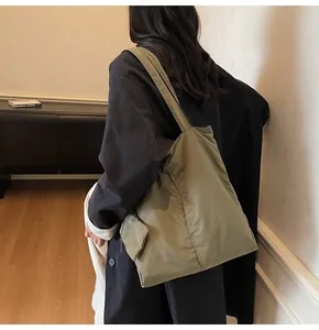 Detail of olive green large tote bag showing outer flap pocket and premium nylon texture