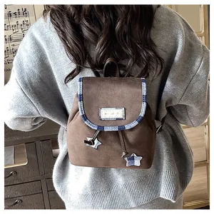 Detail of vintage brown mini backpack with plaid star charms and drawstring design
