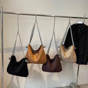 Minimalist suede tote bag with woven wide shoulder strap and side knot details