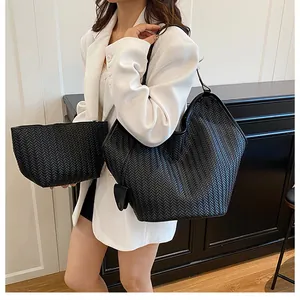 Dettaglio della trama intrecciata nera e della pochette coordinata sulla borsa tote