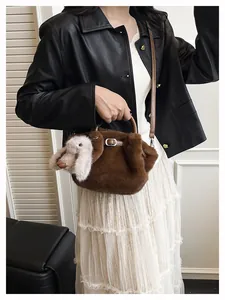 Détail du sac seau en peluche marron foncé avec ornement lapin blanc et bandoulière