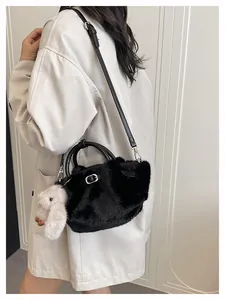 Détail du sac seau en fausse fourrure noire avec poignée cuir et charm lapin blanc
