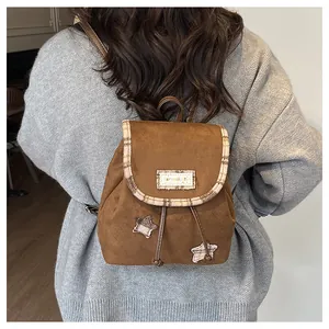 Close-up of small brown suede backpack with star patches and Serendipity label