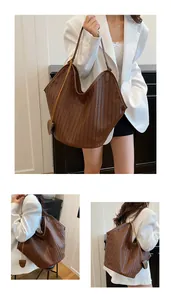 Dettaglio di una grande borsa tote marrone scuro intrecciata con elegante motivo intrecciato