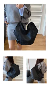 Dettaglio ravvicinato della borsa shopper nera intrecciata con motivo chevron e pelle morbida