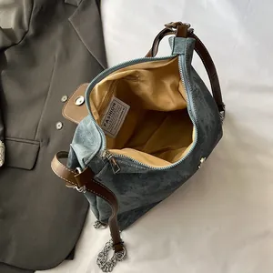 Sac bandoulière en denim avec brides en cuir et détails de chaîne, intérieur spacieux