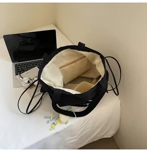 Interior view of black canvas tote bag with cream lining and organized storage compartments