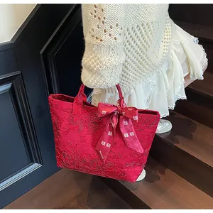 Dettaglio borsa tote in jacquard rosso con fiocco di raso e simbolo di nozze cinese Xi