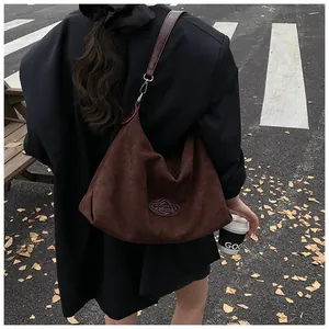 Detailed view of the dark brown suede hobo tote bag with vintage texture and sleek shoulder strap