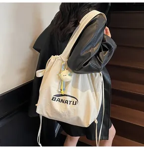 Close-up of cream canvas tote bag with drawstring closure and star plush pendant