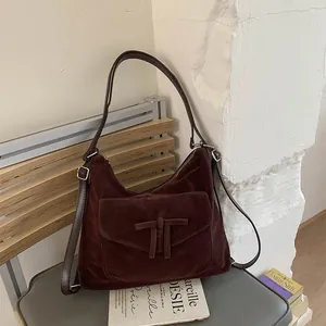 Retro brown suede hobo bag with large capacity and shoulder strap on a grey stool