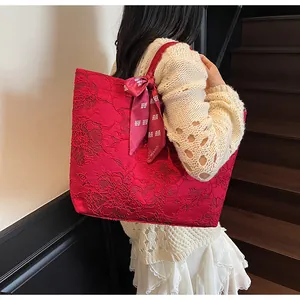 Dettaglio borsa tote rossa con pizzo floreale e sciarpa decorativa con tema nuziale