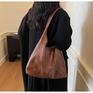 Vista dettagliata della borsa tote vintage marrone indossata con un cappotto nero