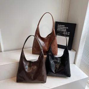 Tre grandi borse tote rétro in ecopelle nei colori marrone, caffè e nero su gradini di marmo