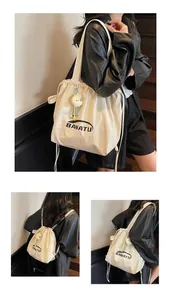 Detail of beige nylon tote bag with BANATU logo and a cute yellow chick plush charm accessory