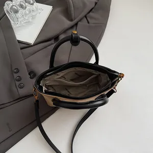 Sac fourre-tout beige et noir montrant l'intérieur spacieux et la doublure chic