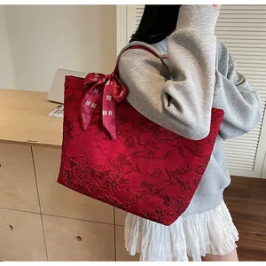 Dettaglio della borsa tote jacquard rossa con fiocco decorativo e nodo nuziale cinese