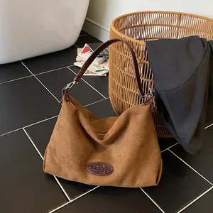 Minimalist brown suede tote bag with leather strap in a stylish lifestyle home setting