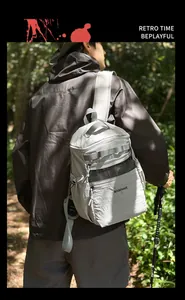 Outdoor light gray crossbody bag with BOGEWADE logo shown in a forest setting