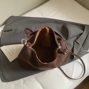Minimalist brown suede tote bag with leather straps and spacious interior for daily use
