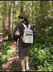 Outdoor view of a durable grey backpack being worn on a hiking trail in the forest