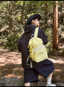 Detail of yellow sports backpack with grey mesh pocket and reflective strap on the shoulder