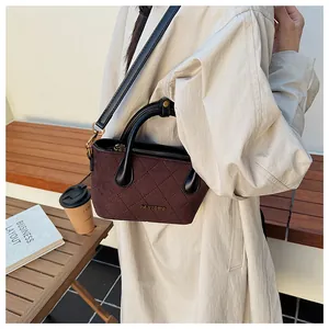 Détail du sac cabas matelassé en daim bordeaux avec poignées en cuir noir