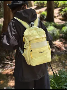 Detail of a bright yellow waterproof nylon backpack with mesh pocket and brand logo