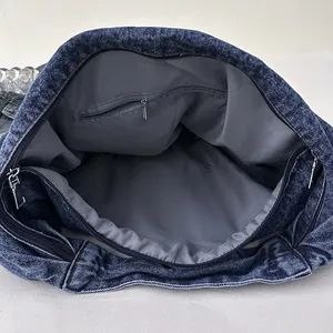 Large denim tote bag with spacious interior compartment and secure zipper closure