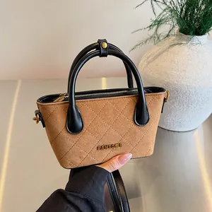 Sac seau vintage en daim marron matelassé avec logo doré et deux anses noires