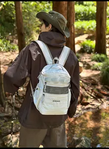 Outdoor scenic view of a grey waterproof backpack with black mesh pocket on hiking trail