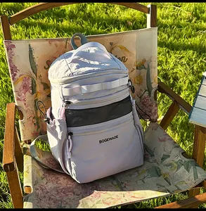 Detail of lavender nylon backpack with multiple compartments on a garden chair