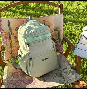 Detail of mint green nylon sports backpack with black logo on a folding chair